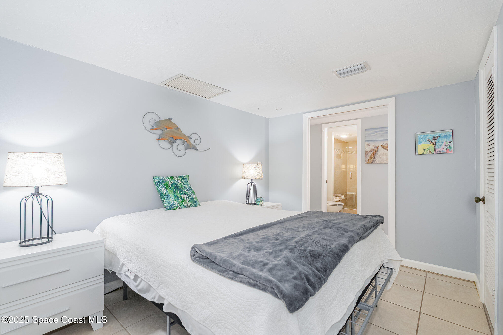 5000 Ocean Beach Boulevard, Unit C5 Cocoa Beach, FL 32931 - Photo 15 of 31 a bedroom with a large bed and a chandelier