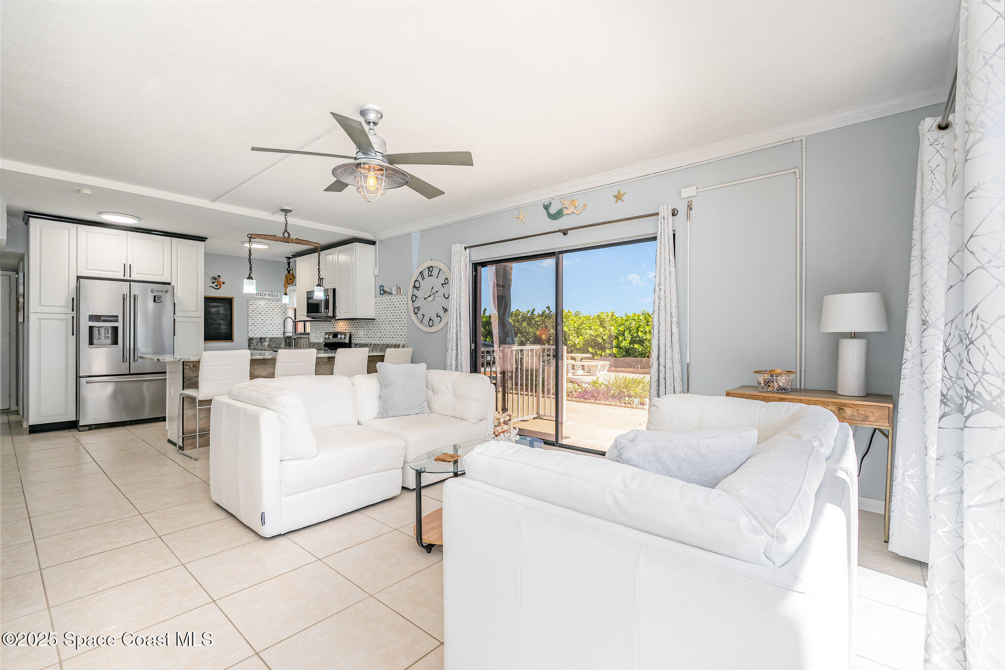 5000 Ocean Beach Boulevard, Unit C5 Cocoa Beach, FL 32931 - Photo 3 of 31 a living room with furniture and a large window