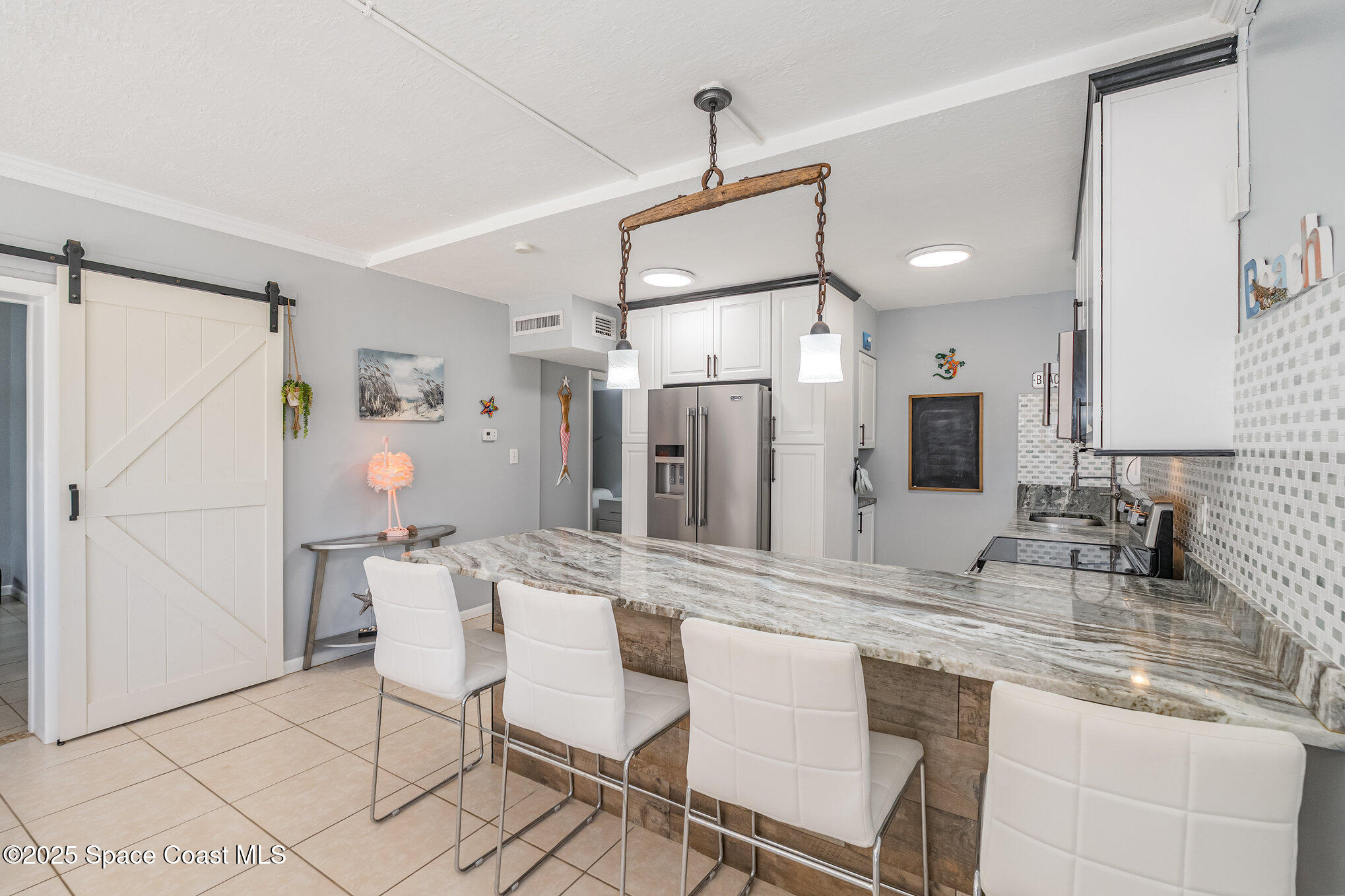 5000 Ocean Beach Boulevard, Unit C5 Cocoa Beach, FL 32931 - Photo 6 of 31 a kitchen with granite countertop a sink cabinets and stainless steel appliances