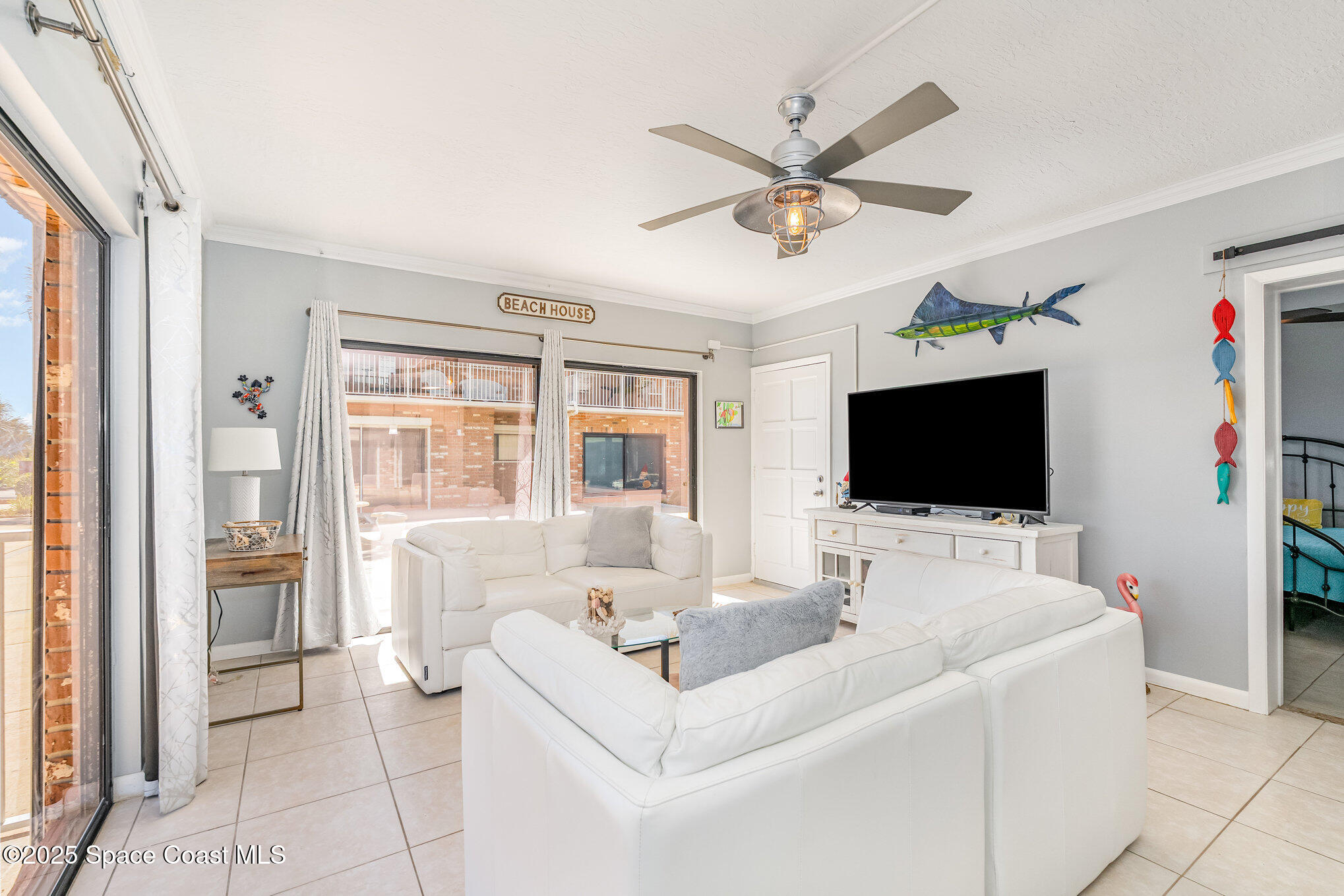 5000 Ocean Beach Boulevard, Unit C5 Cocoa Beach, FL 32931 - Photo 8 of 31 a living room with furniture and a flat screen tv