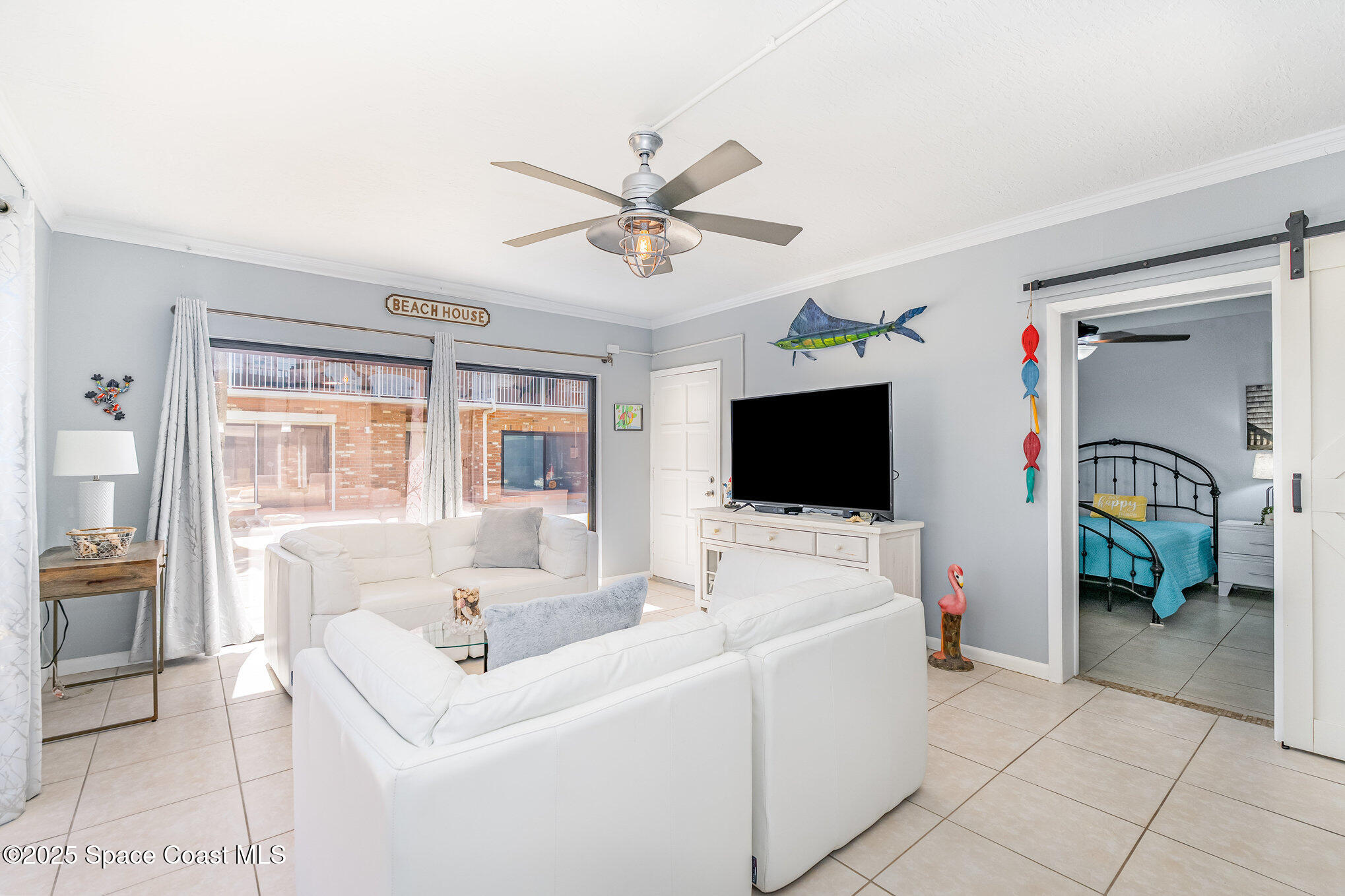 5000 Ocean Beach Boulevard, Unit C5 Cocoa Beach, FL 32931 - Photo 10 of 31 a living room with furniture and a flat screen tv