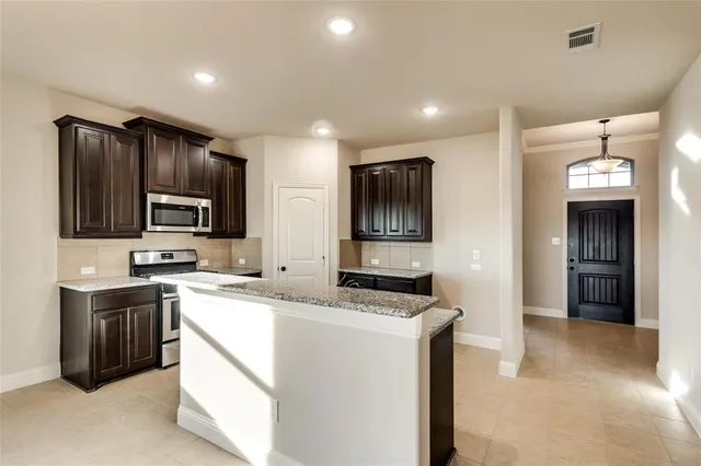 a kitchen that has a sink cabinets and stainless steel appliances