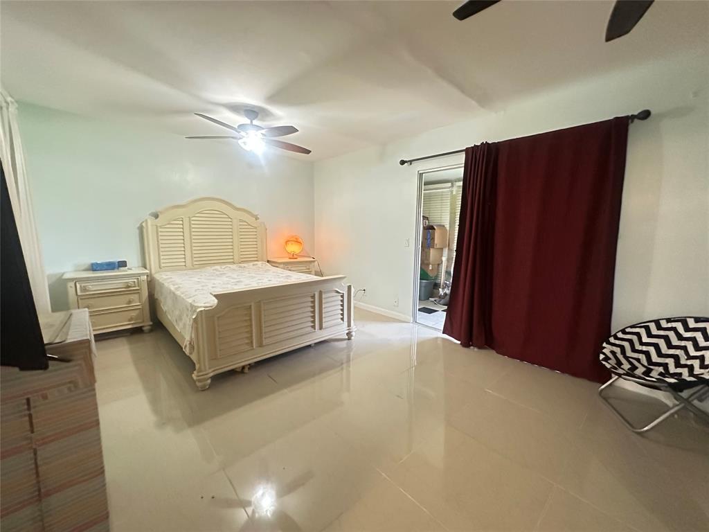 84 Farnham East, Unit 84 Deerfield Beach, FL 33442 - Photo 12 of 57 a spacious bedroom with a bed and a chandelier