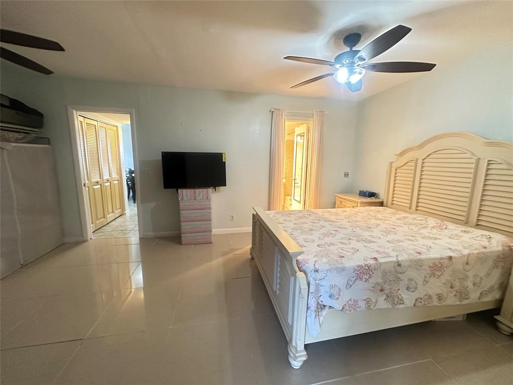 84 Farnham East, Unit 84 Deerfield Beach, FL 33442 - Photo 13 of 57 a bedroom with a bed and a flat screen tv