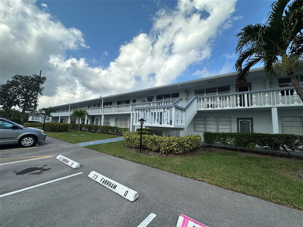 84 Farnham East, Unit 84 Deerfield Beach, FL 33442 - Photo 22 of 57 a view of a white house next to a yard with big trees