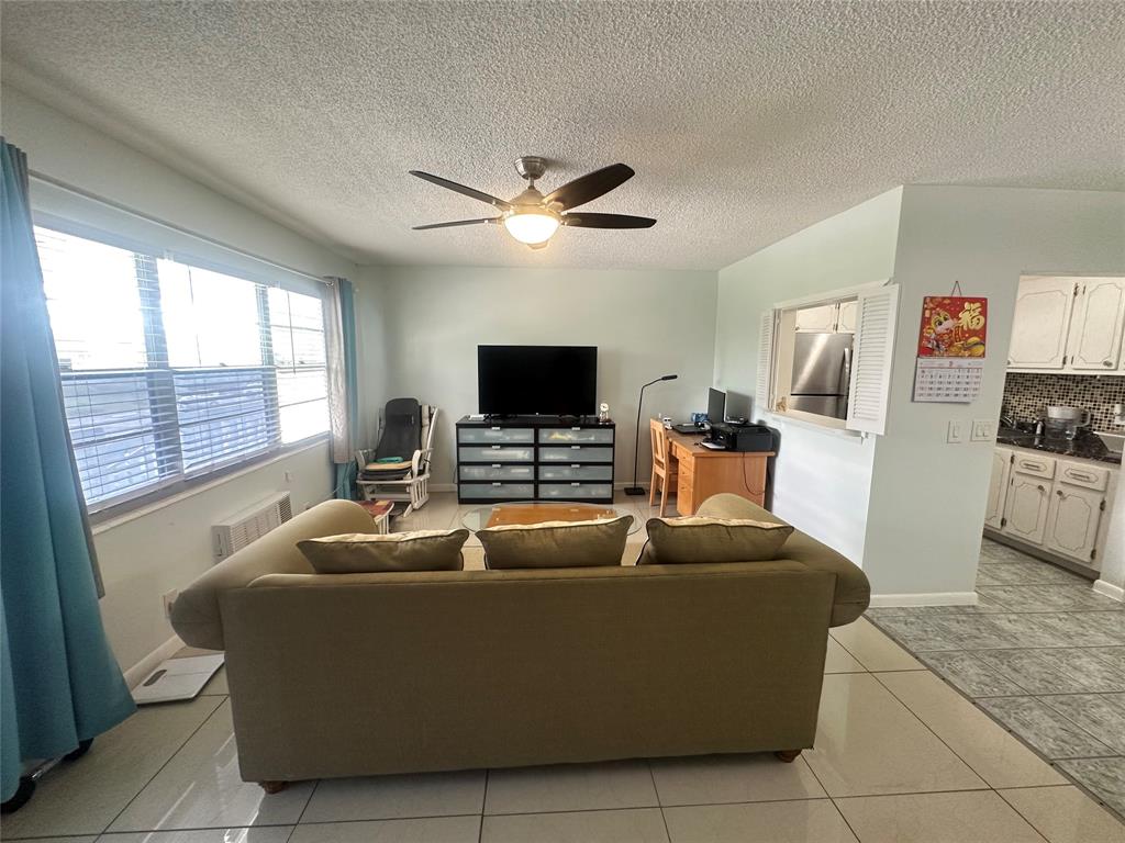 84 Farnham East, Unit 84 Deerfield Beach, FL 33442 - Photo 5 of 57 a living room with furniture and a flat screen tv