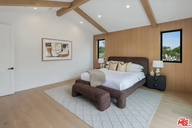 a bedroom with a bed and a view of living room