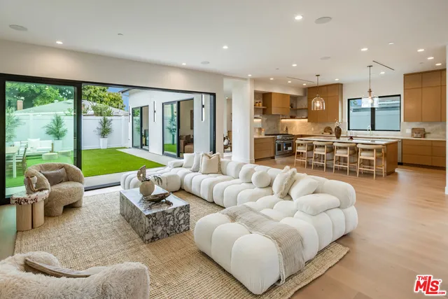 a kitchen with stainless steel appliances granite countertop table chairs sink and stove