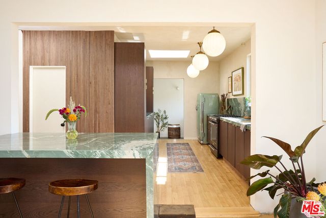 a kitchen with granite countertop a stove a sink and a wooden cabinets