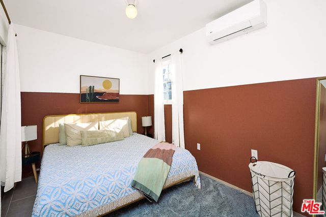 a bedroom with a bed couch and a window