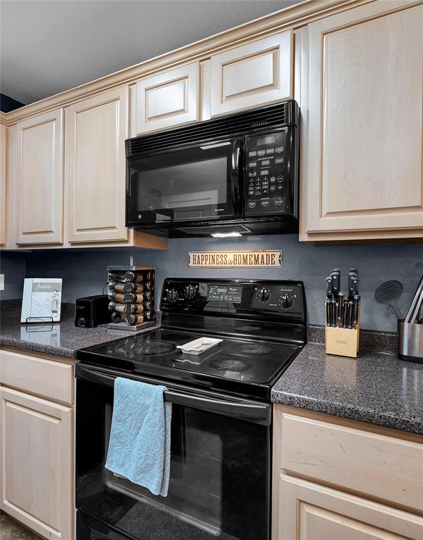 37 Bluebonnet Loop Morgan's Point Resort, TX 76513 - Photo 12 of 38 Kitchen featuring light-toned cabinetry with crown molding, dark speckled countertops, a black electric range, and an over-the-range microwave