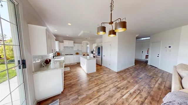 a living room with kitchen island furniture and a chandelier