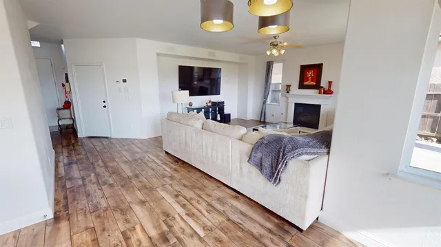 a living room with furniture and a wooden floor