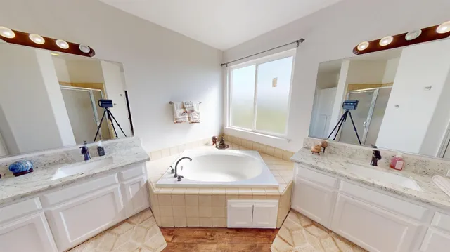 a bathroom with a tub sink and mirror