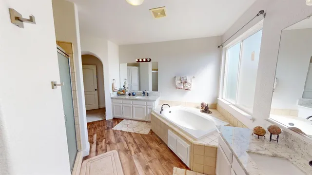 a spacious bathroom with a bathtub sink and mirror