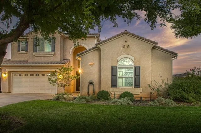 a front view of a house with a garden