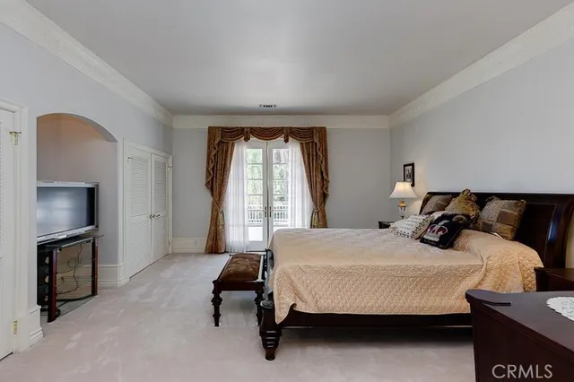 a bedroom with a bed a fireplace and a large window