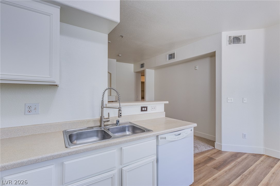 9050 West Warm Springs Road, Unit 1011 Las Vegas, NV 89148 - Photo 6 of 32 A well-appointed kitchen featuring dual stainless steel sinks and a modern pull-down faucet.