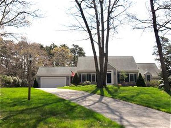 a view of a house with a small yard and a large tree