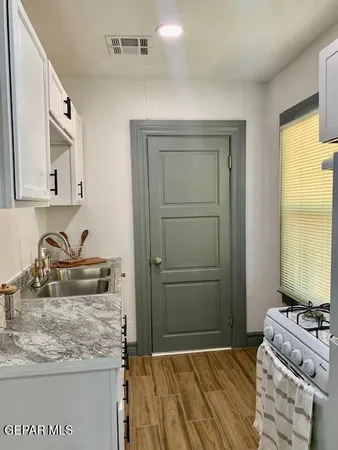 a kitchen with a sink stove and cabinets
