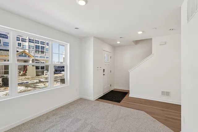 an empty room with a window and wooden floor