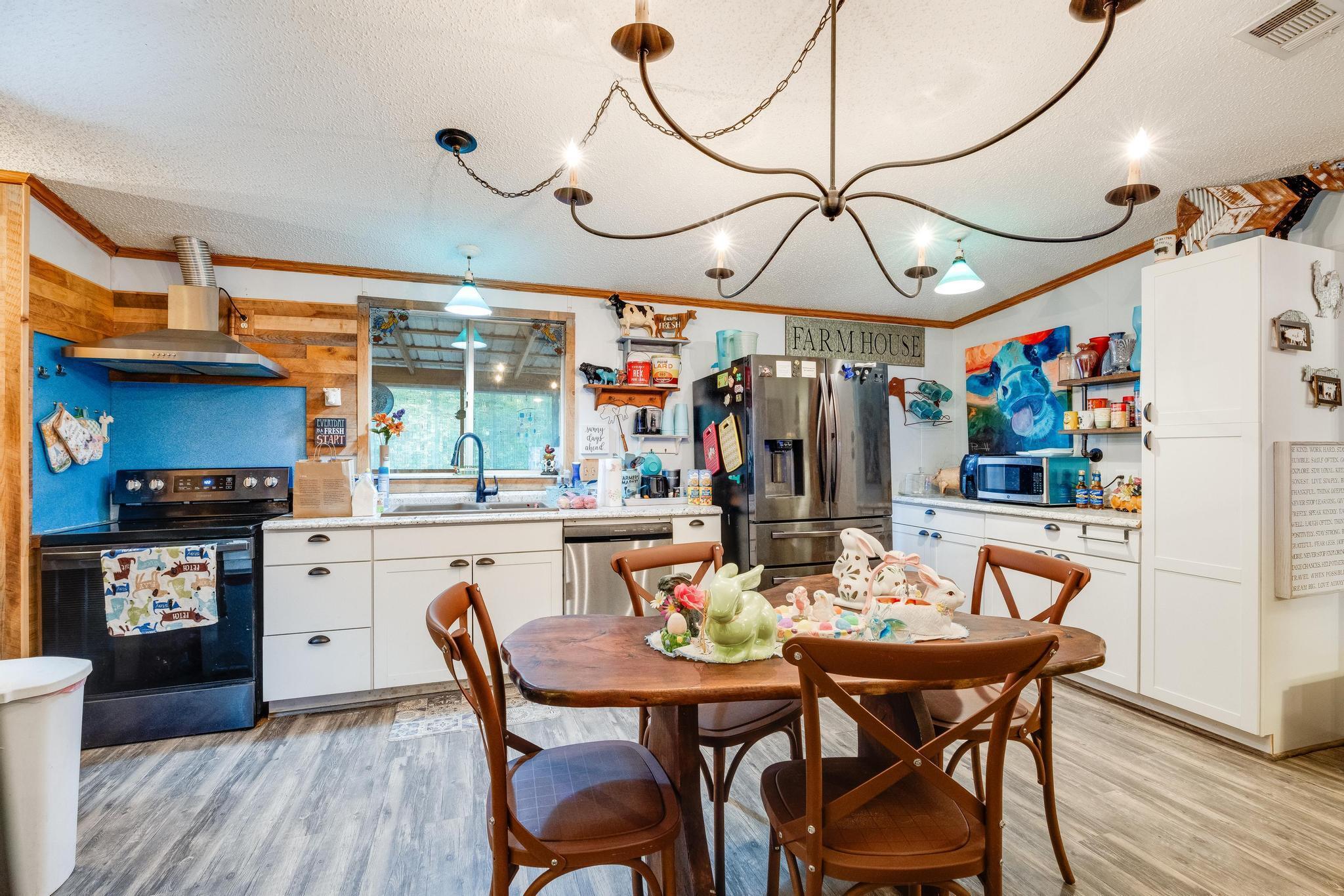 a kitchen with stainless steel appliances granite countertop a dining table and chairs with wooden floor