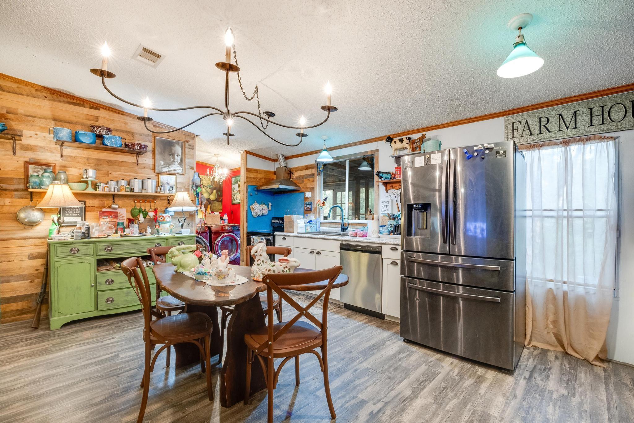 5084 Richardson Road Crestview, FL 32539 - Photo 2 of 24 a kitchen with stainless steel appliances granite countertop a refrigerator a sink dishwasher a dining table and chairs with wooden floor