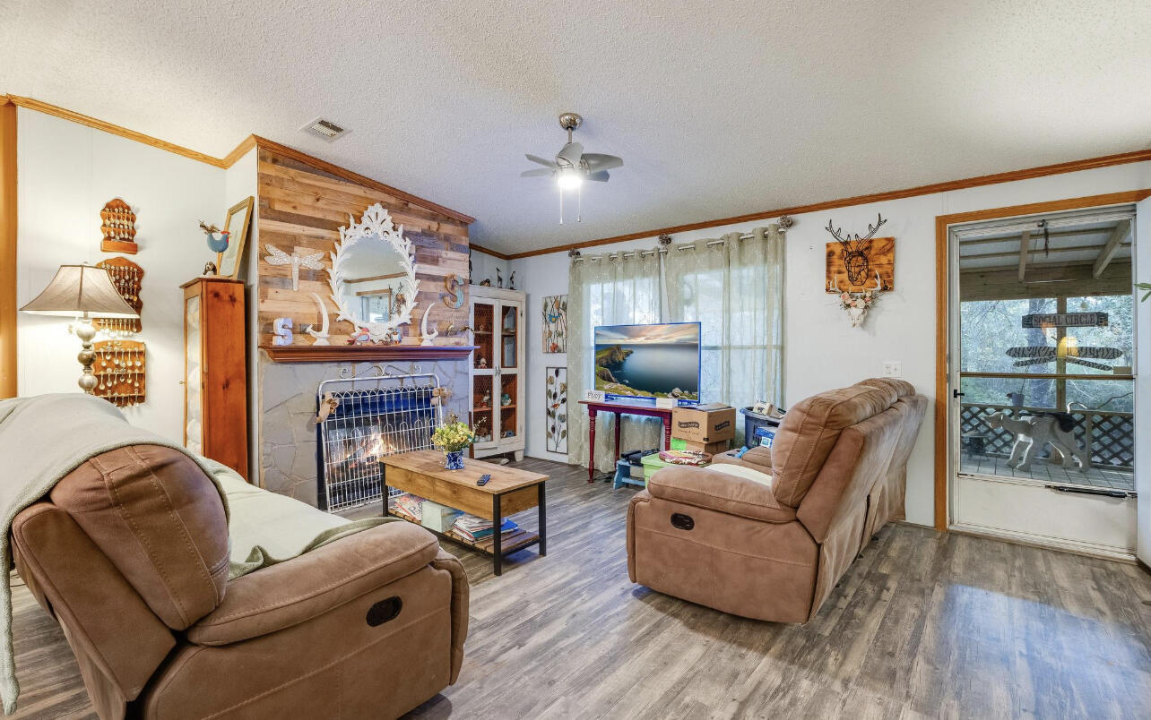 5084 Richardson Road Crestview, FL 32539 - Photo 5 of 24 a living room with furniture a fireplace and a flat screen tv