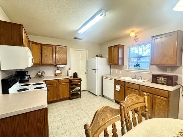 a kitchen with stainless steel appliances kitchen island granite countertop a sink dishwasher stove refrigerator and microwave