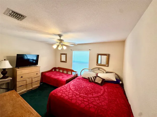 a bedroom with two beds and a flat screen tv