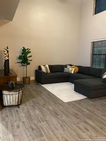 a living room with furniture and wooden floor