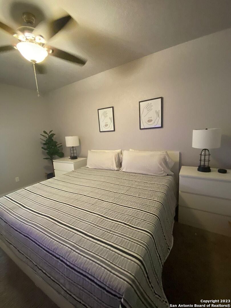 6160 Eckhert Road, Unit 1406 San Antonio, TX 78240 - Photo 10 of 14 a bedroom with a bed and a lamp