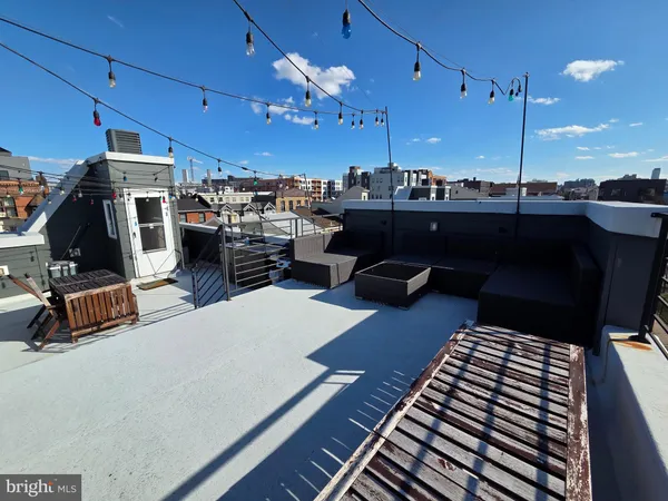 a living room with furniture a flat screen tv and kitchen view