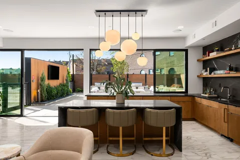 a living room with stainless steel appliances kitchen island granite countertop a sink and cabinets