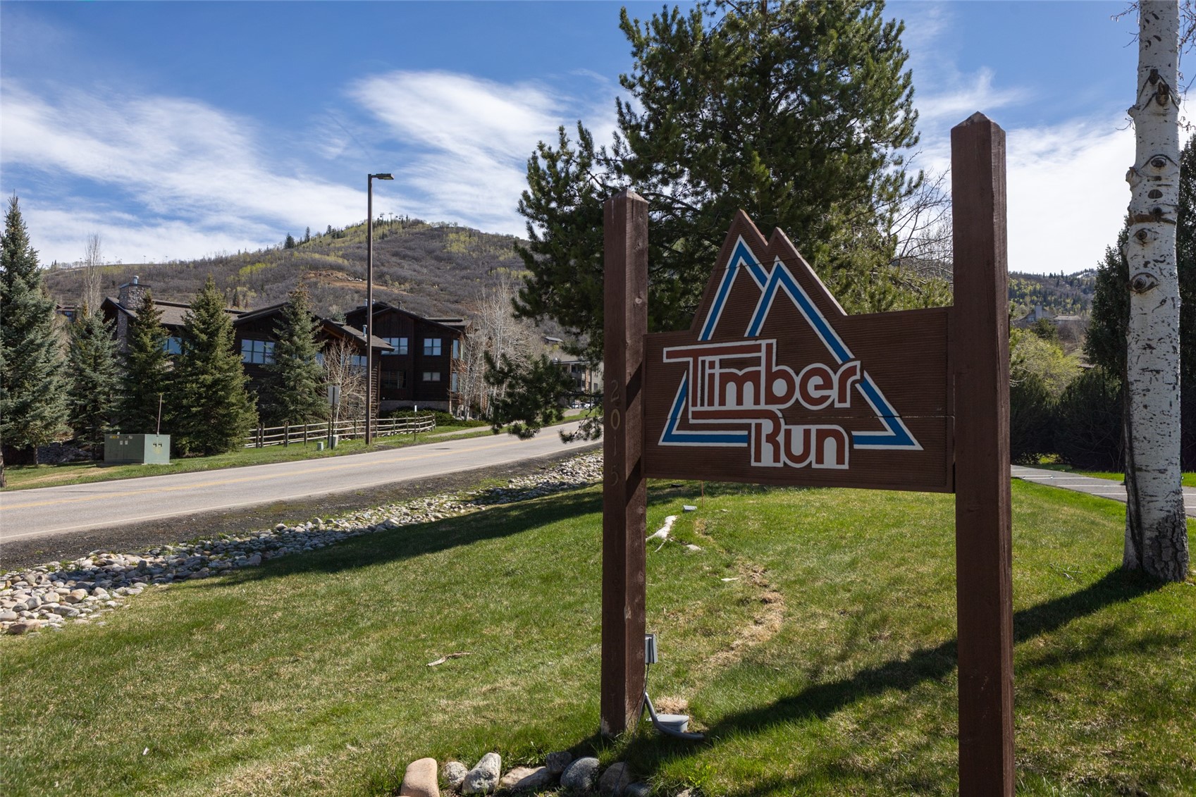 2025 Walton Creek Road, Unit 308 Steamboat Springs, CO 80487 - Photo 24 of 34 a view of a wooden house with a small yard and wooden fence