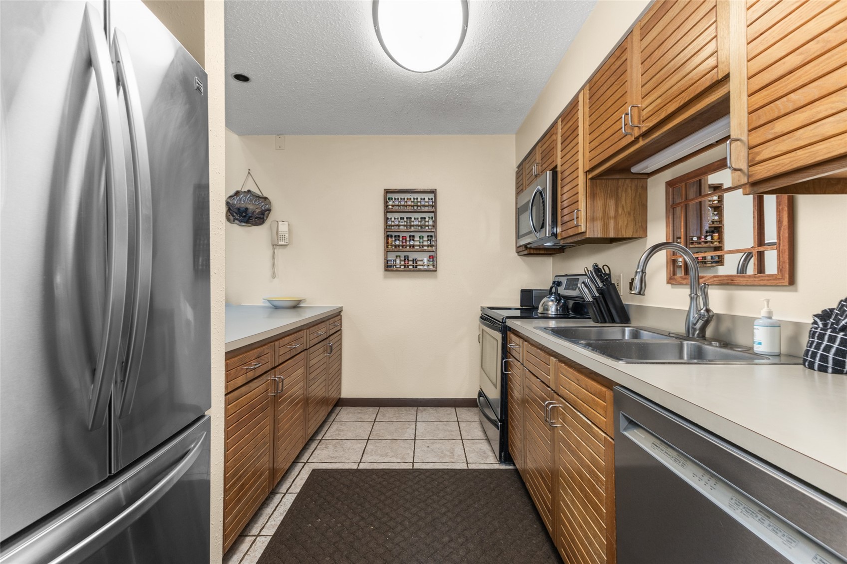 2025 Walton Creek Road, Unit 308 Steamboat Springs, CO 80487 - Photo 9 of 34 a kitchen with stainless steel appliances granite countertop a sink and a refrigerator