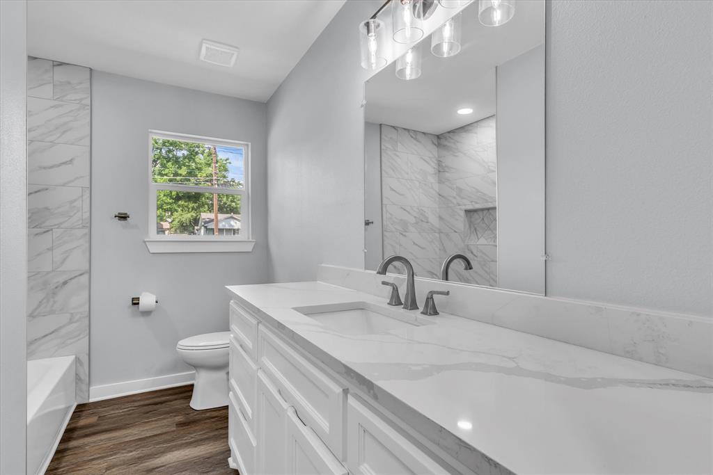 3608 North 26th Street Waco, TX 76708 - Photo 18 of 28 a bathroom with a sink a toilet and a large mirror