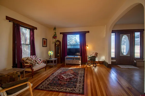 a view of livingroom with furniture chandelier and front door