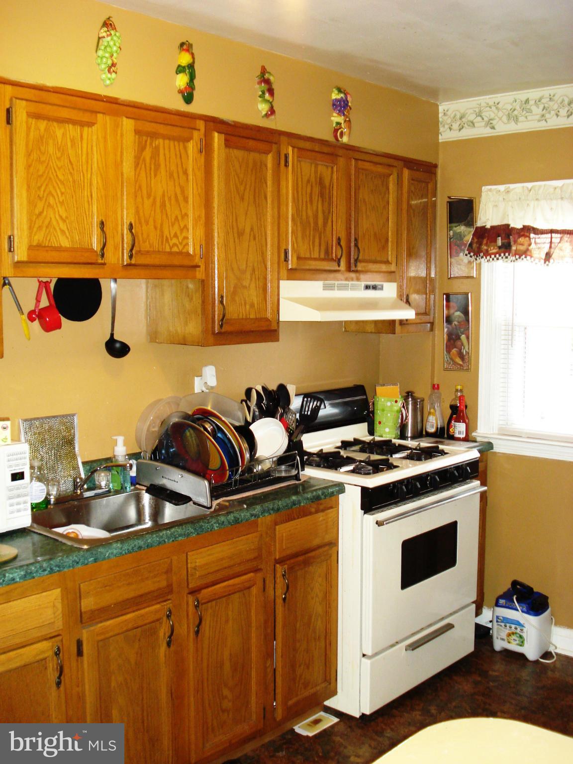 3906 Flowerton Road Baltimore, MD 21229 - Photo 14 of 27 a kitchen with stainless steel appliances granite countertop a stove a sink and a microwave