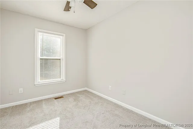 an empty room with a chandelier fan
