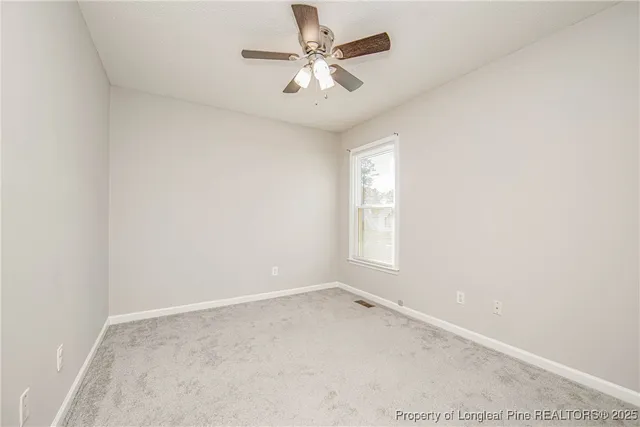 an empty room with a chandelier fan and closet