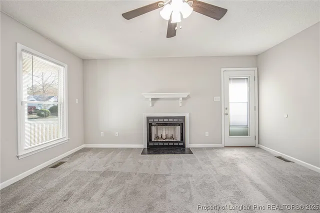 an empty room with fireplace and fan