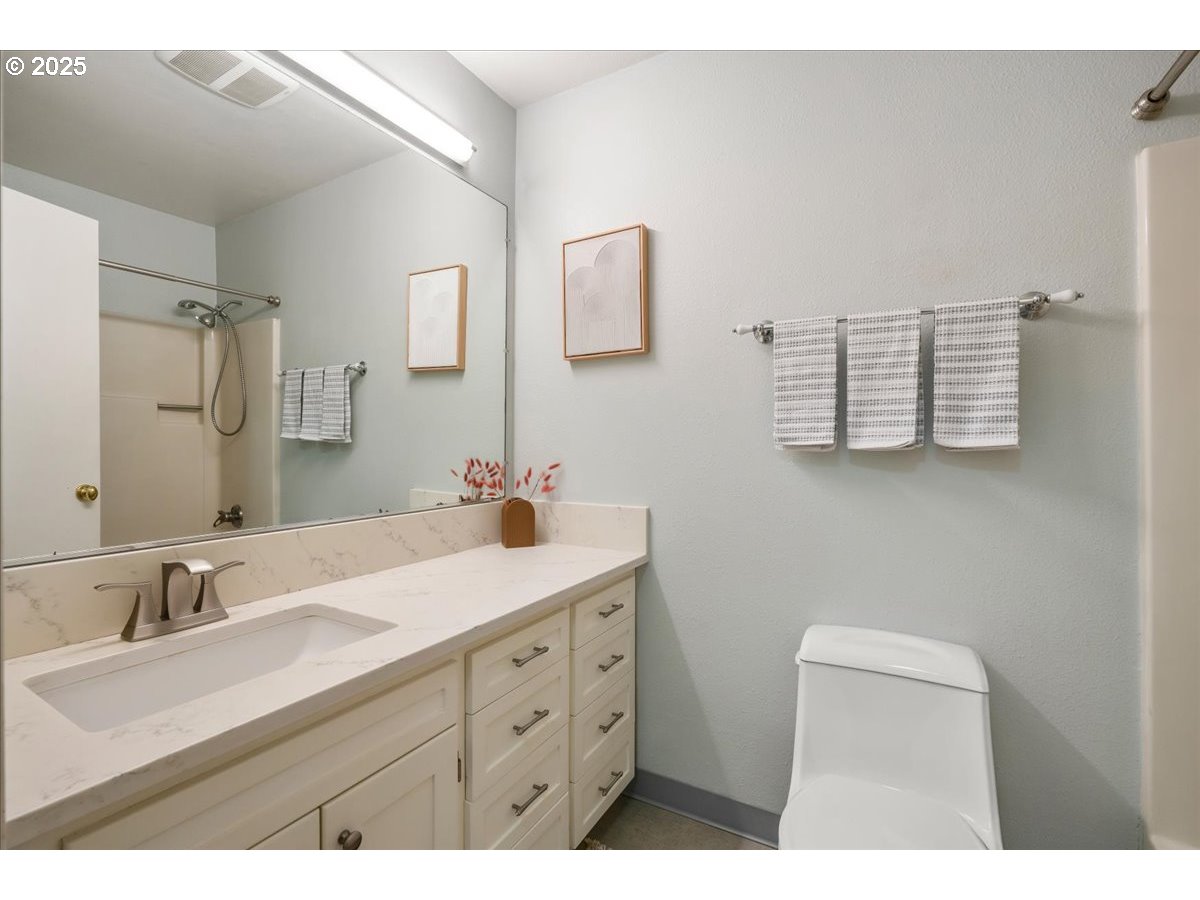 3515 Southwest Barbur Boulevard, Unit P1 Portland, OR 97239 - Photo 19 of 35 a bathroom with a sink vanity granite and a mirror