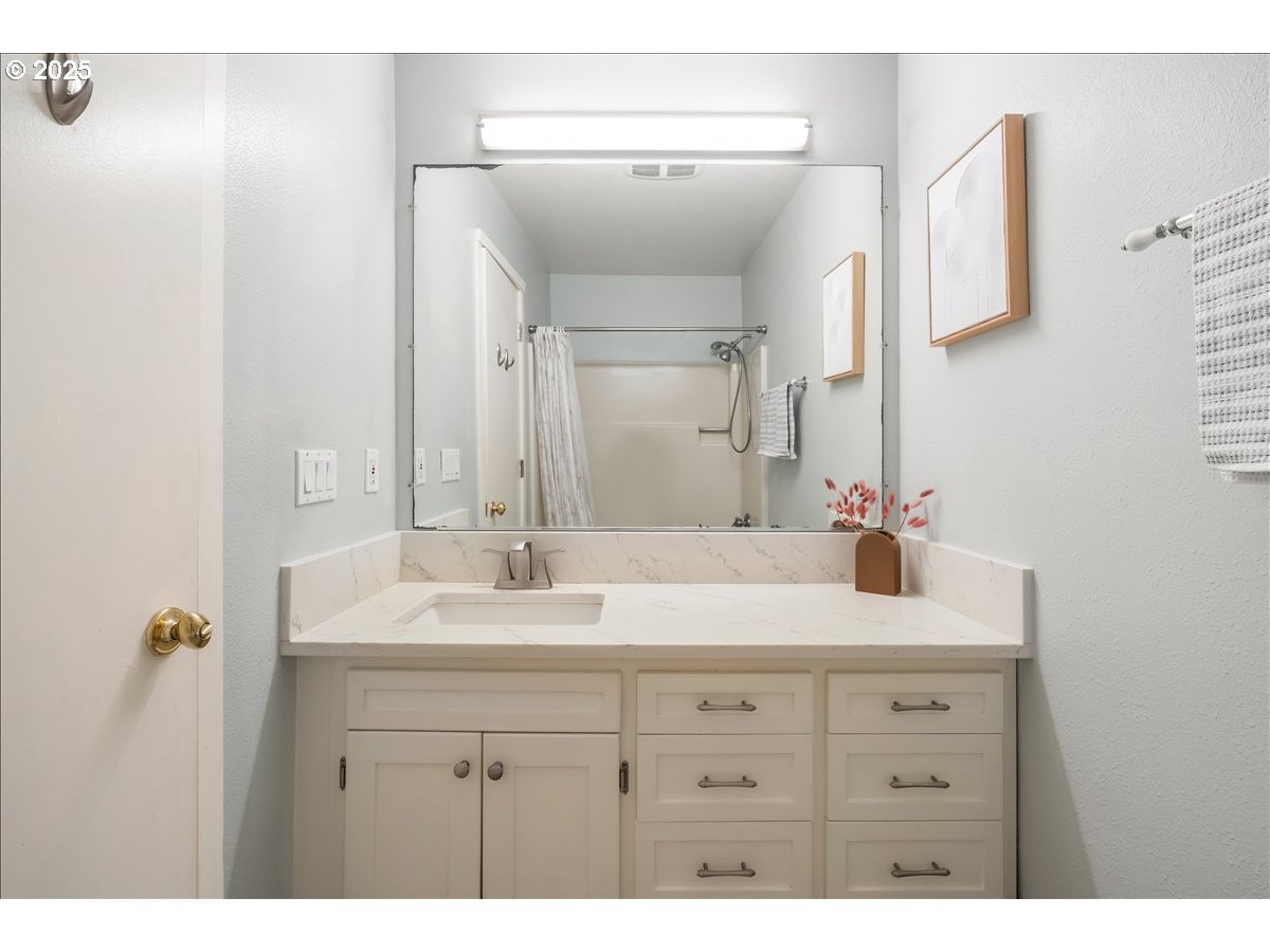 3515 Southwest Barbur Boulevard, Unit P1 Portland, OR 97239 - Photo 20 of 35 a bathroom with a sink vanity granite and a mirror