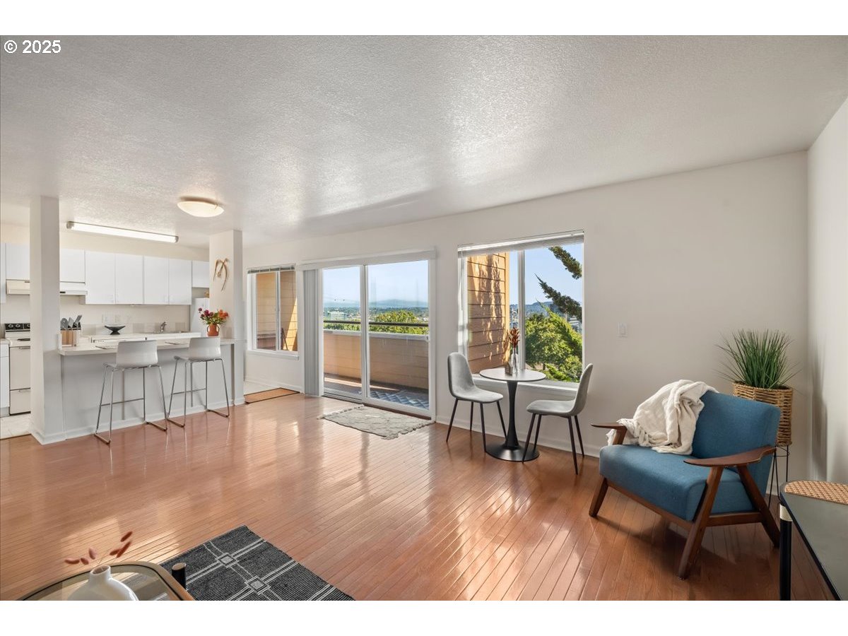 3515 Southwest Barbur Boulevard, Unit P1 Portland, OR 97239 - Photo 8 of 35 a living room with furniture and a wooden floor