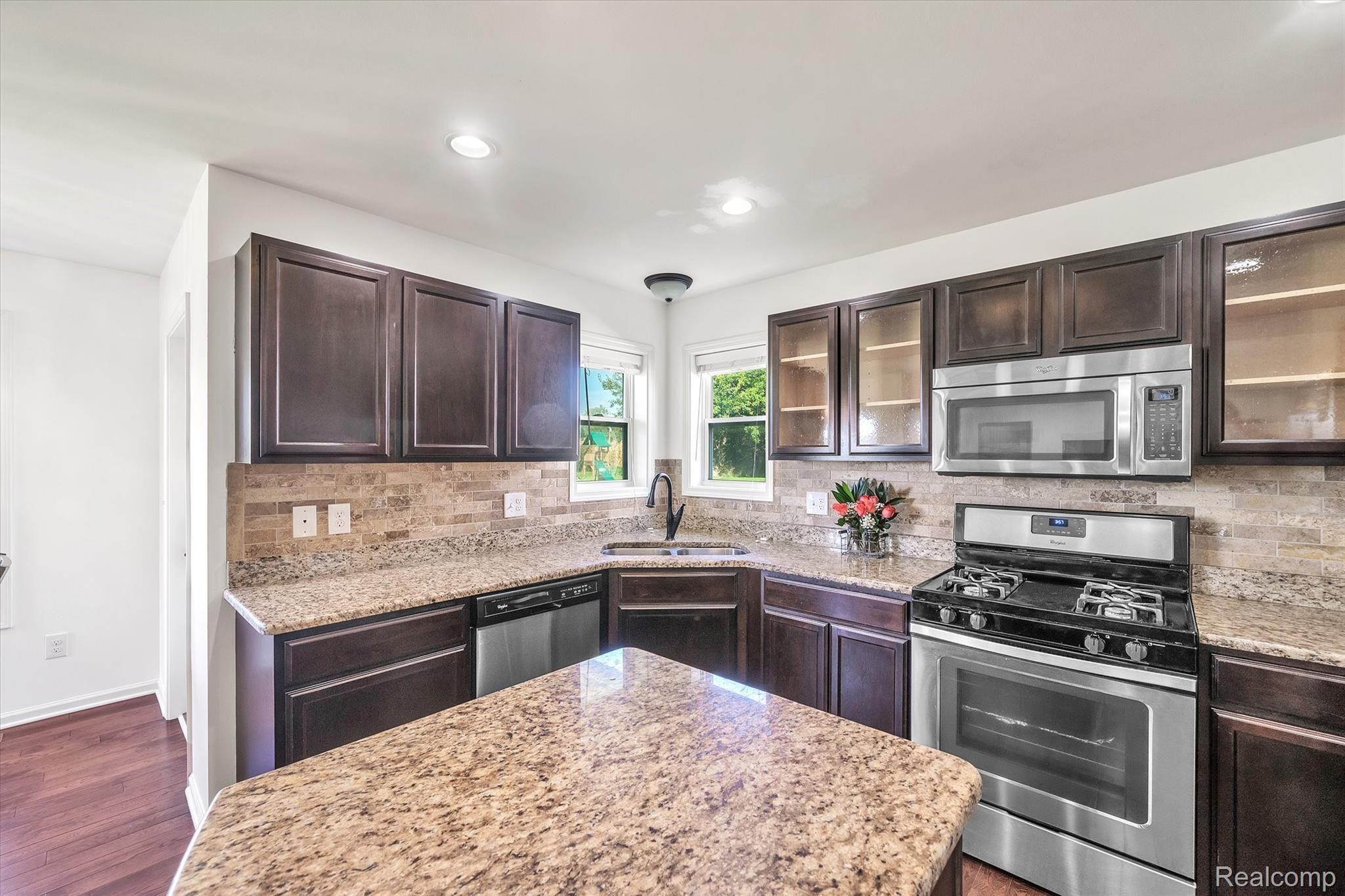 8116 Eagle Ridge Lane Fowlerville, MI 48836 - Photo 8 of 36 Upgraded Kitchen with backsplash, granite, stainless steel appliances