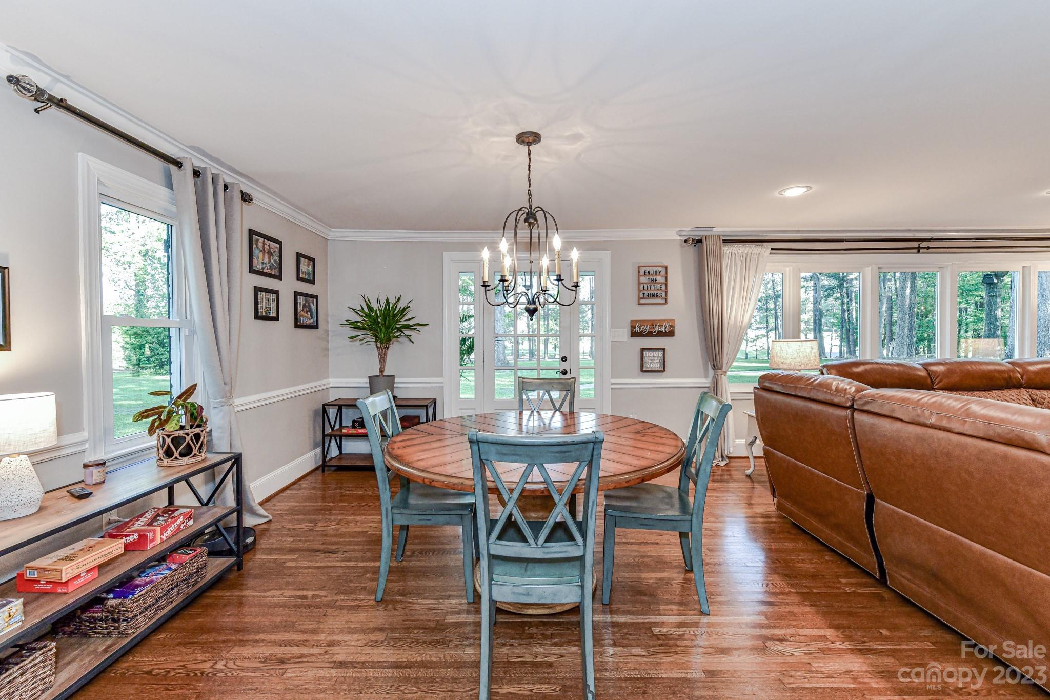 1050 Ben Black Road Midland, NC 28107 - Photo 6 of 48 a dining room with wooden floor a chandelier a wooden table and chairs