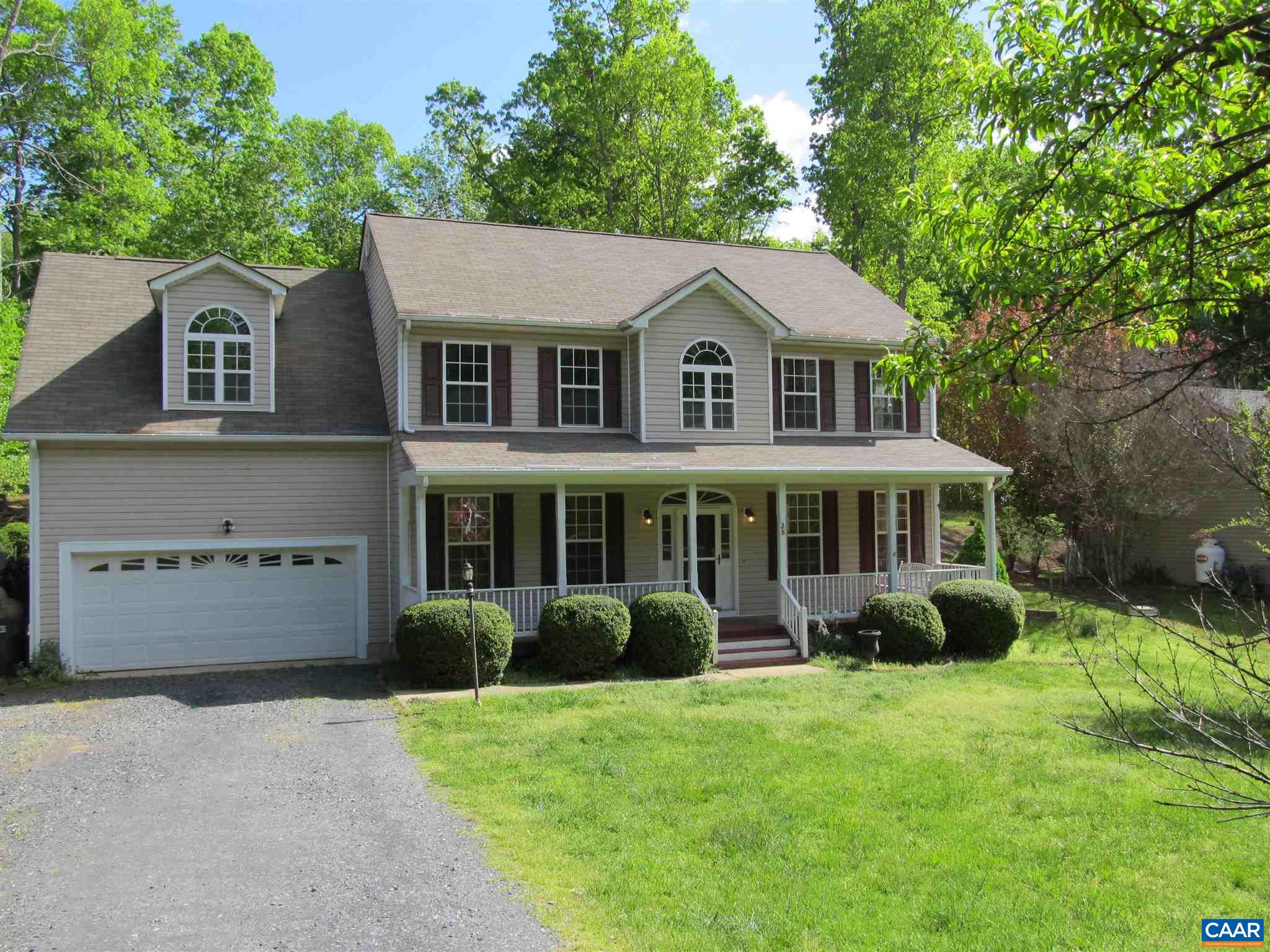 a front view of a house with a garden and plants