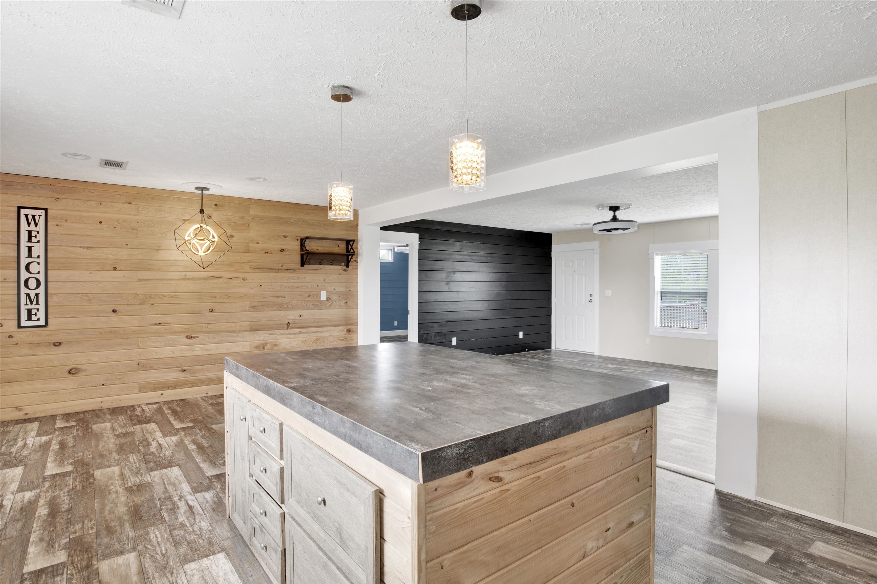 16778 County Road 87 Elberta, AL 36530 - Photo 32 of 32 Kitchen with a center island, wood-type flooring, wood walls, and a textured ceiling