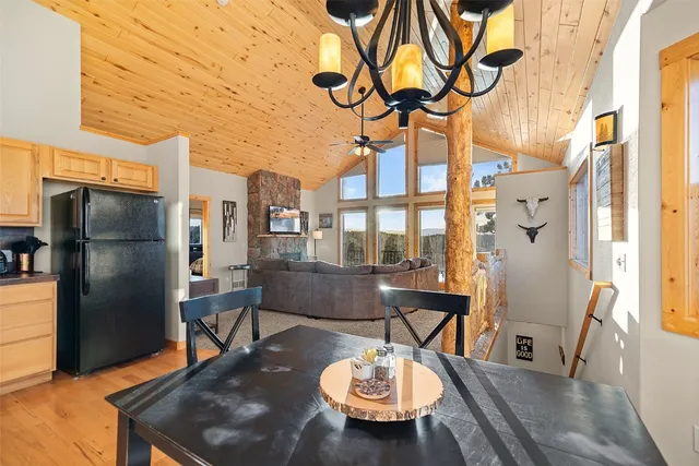 a view of a dining room with furniture a chandelier and wooden floor